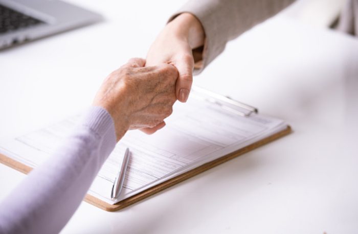 handshake over table with documents